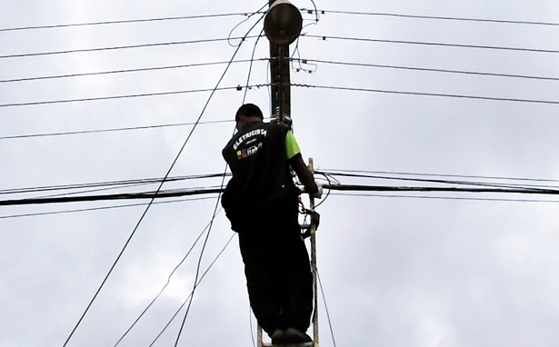 Funcion&aacute;rio da prefeitura fazendo reposi&ccedil;&atilde;o de l&acirc;mpada queimada.