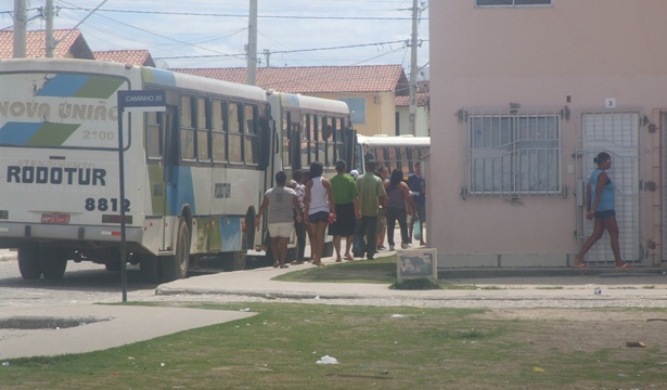 Diversas pessoas entrando nos ônibus, já no conjunto habitacional