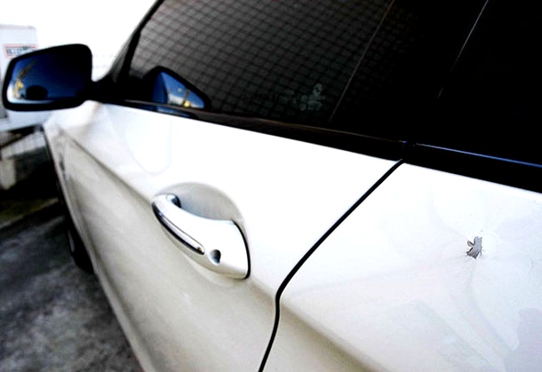 Marca de tiro na lataria do carro de Adriano.